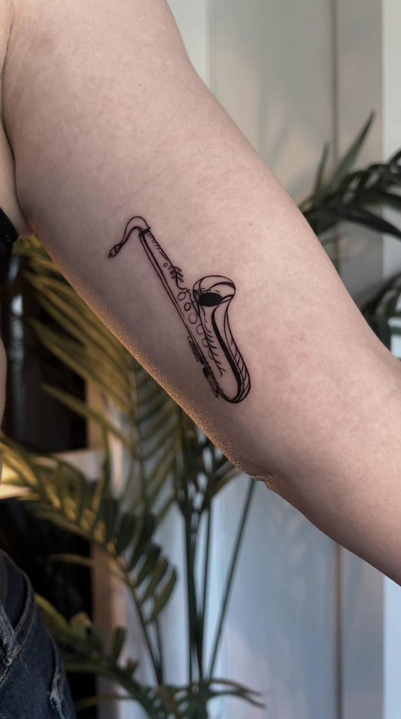 Fine line tattoo Uppsala — saxophone, forearm