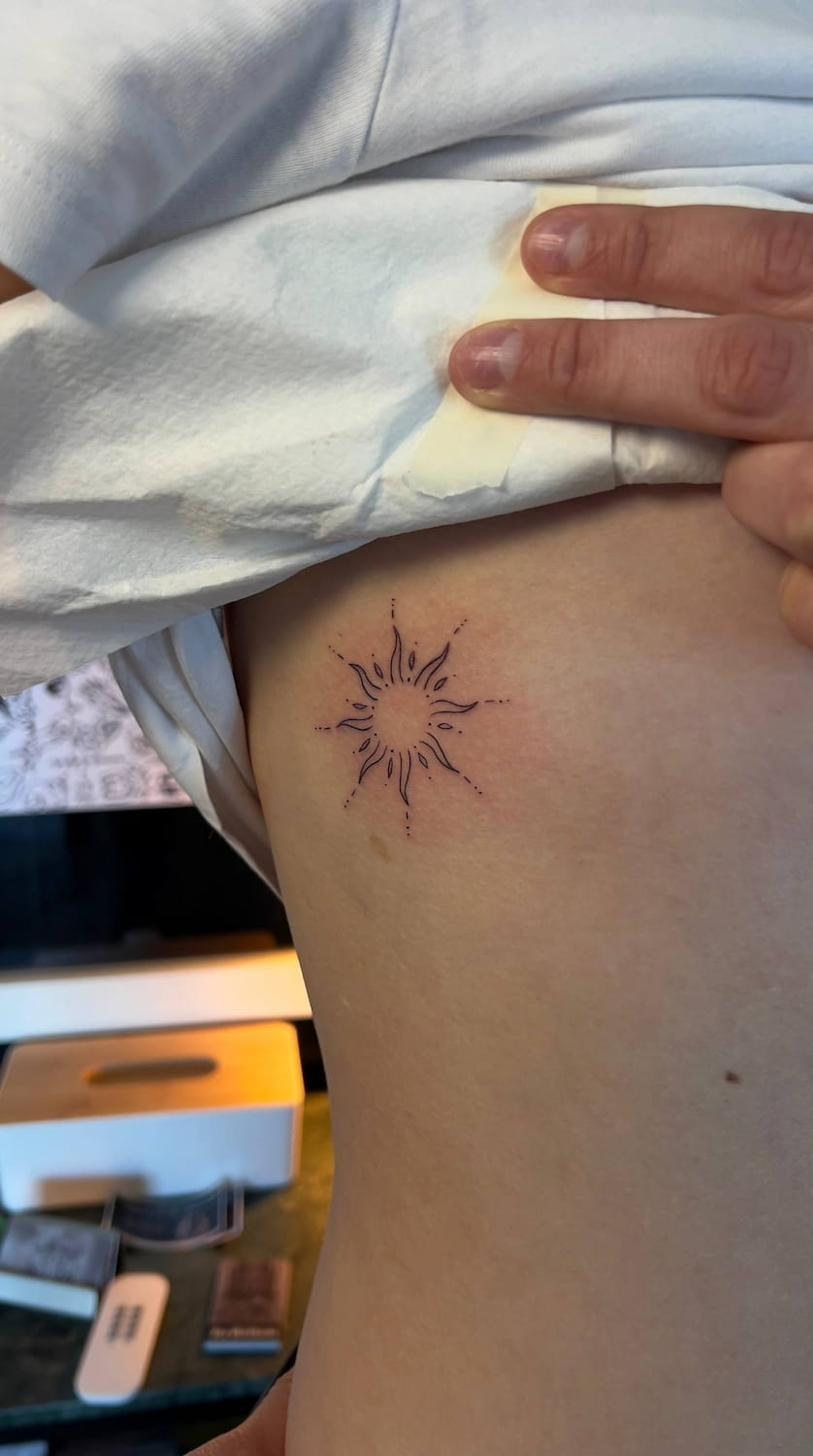 Fine line tattoo near Stockholm — sun motif on ribs