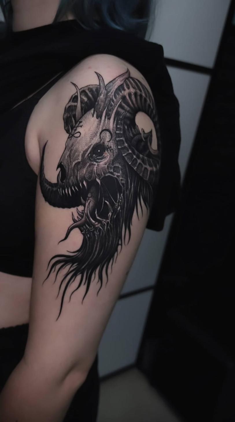 Tattoo Uppsala — surrealist ram skull on shoulder