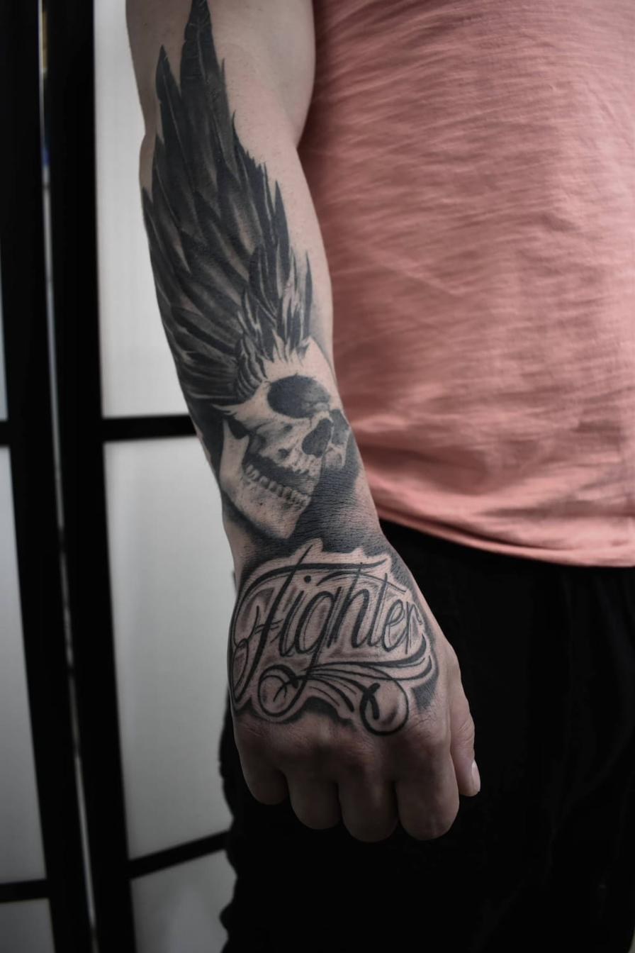 Chicano tattoo Uppsala — skull with wing and 'Fighter' lettering